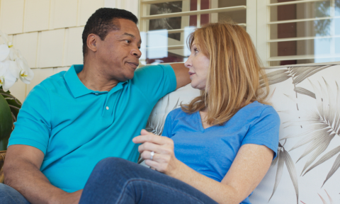 A man and woman have serious conversation on an outdoor patio